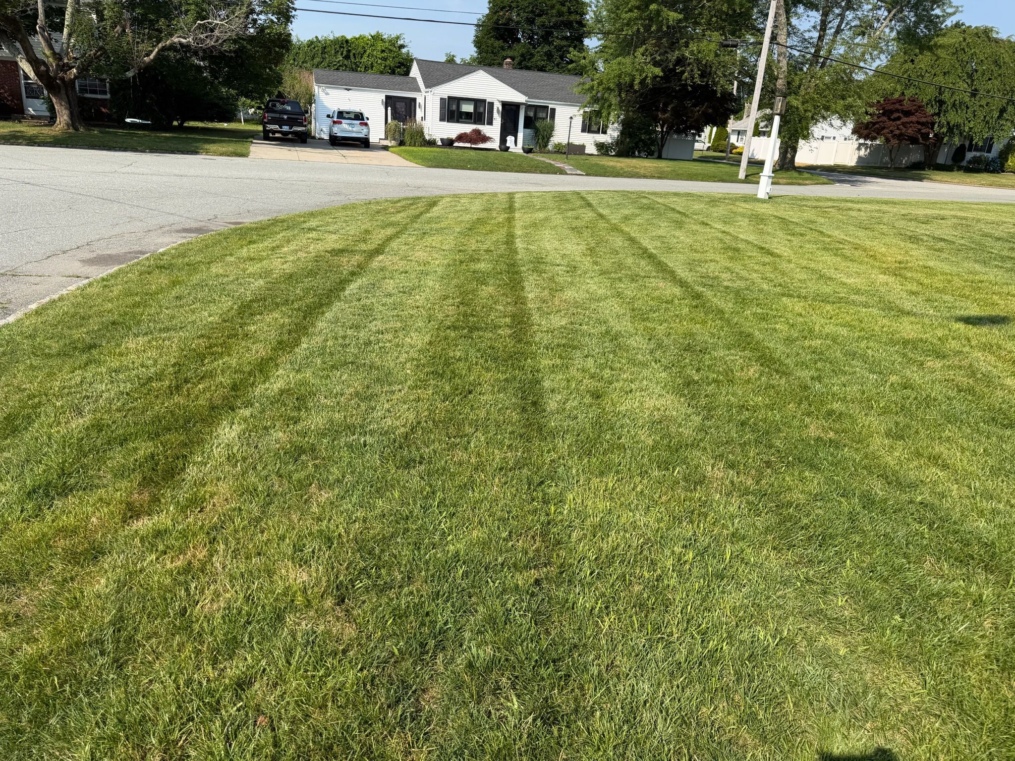 Freshly mowed, healthy green lawn with crisp edges beside a Rhode Island home